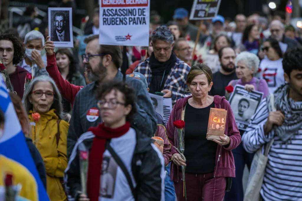 Manifestantes participam da 5ª Caminhada do Silêncio, em São Paulo, com flores, velas e cartazes em homenagem às vítimas da violência de Estado