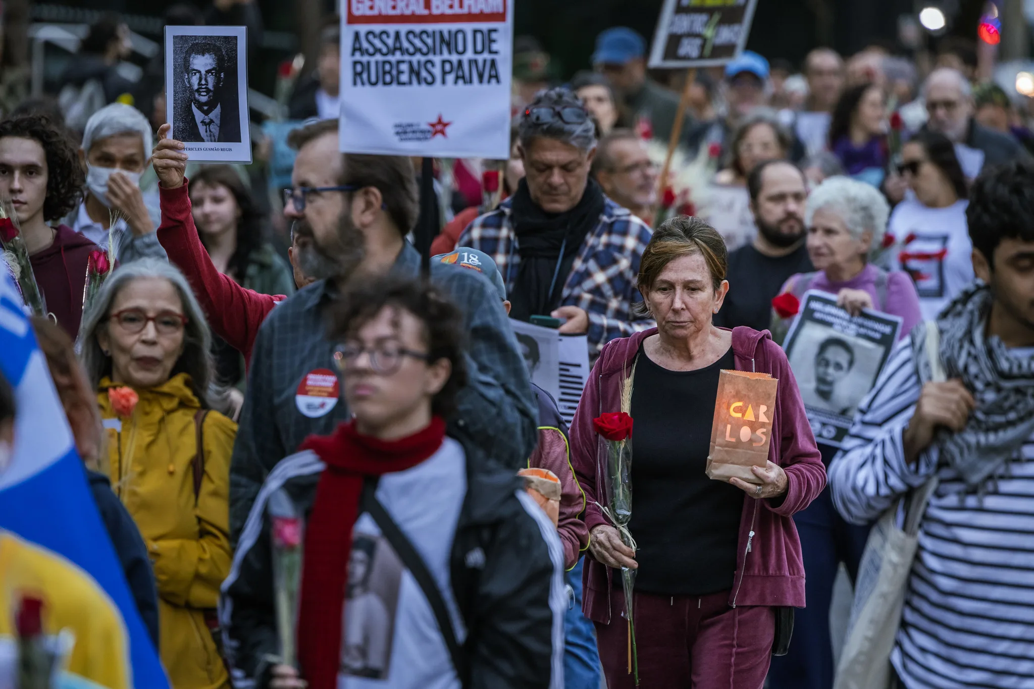 Manifestantes participam da 5ª Caminhada do Silêncio, em São Paulo, com flores, velas e cartazes em homenagem às vítimas da violência de Estado
