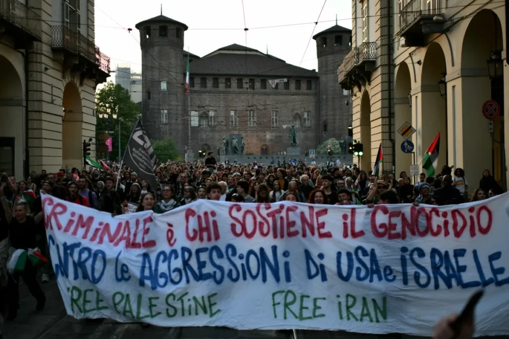 Manifestantes exibem uma faixa com os dizeres "Criminoso é qualquer pessoa que apoie o genocídio diante das agressões dos Estados Unidos e de Israel" durante manifestação em Turim, na Itália, em 10 de abril de 2026