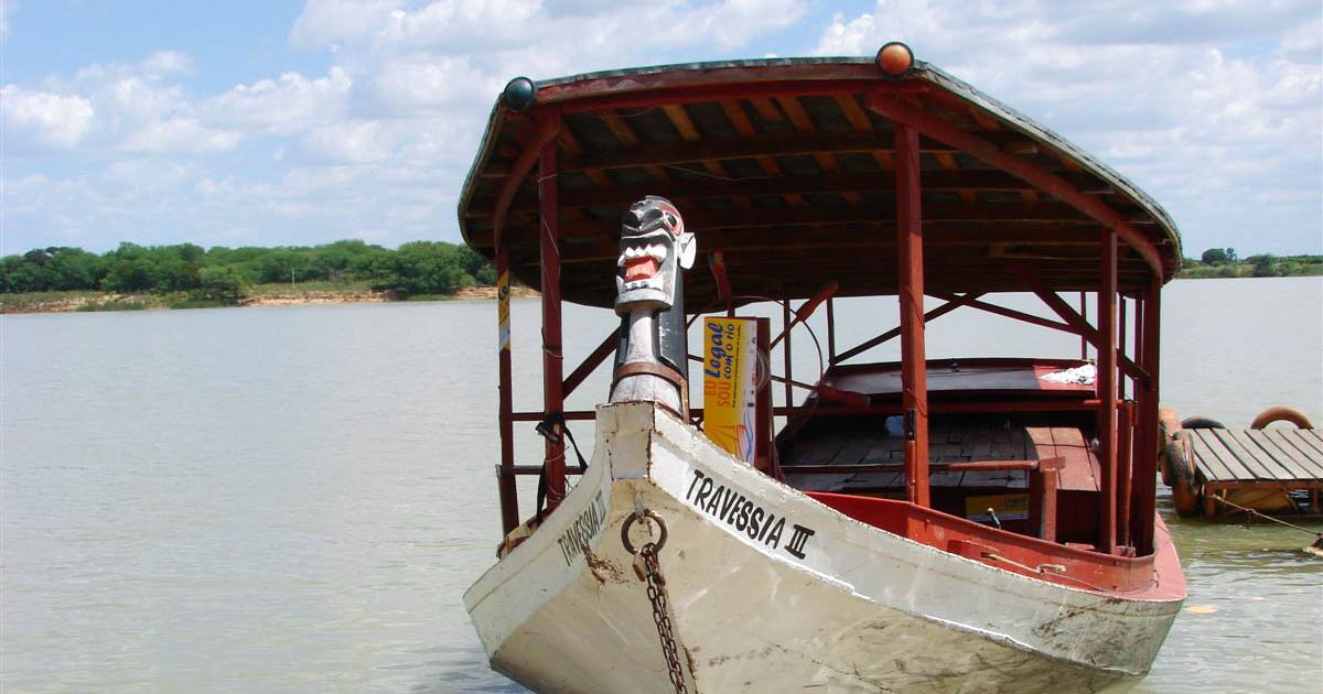 Imagem de uma embarcação flutuando no rio São Francisco. Na proa, ela apresenta o que os ribeirinhos chamam de carranca, a representação simbólica da face de um monstro ou algo semelhante