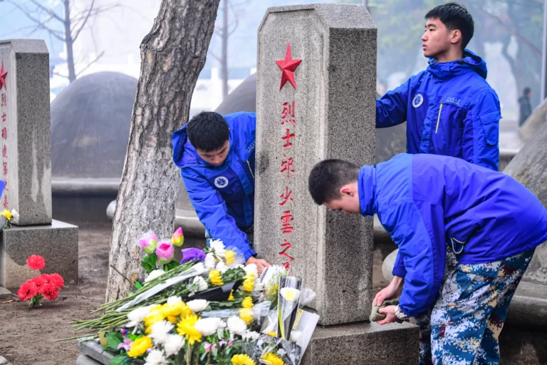Bombeiros limpam o túmulo do soldado chinês Qiu Shaoyun durante o Qingming, no cemitério dos mártires dos Voluntários do Povo Chinês em Shenyang, na província de Liaoning, no nordeste da China, em 5 de abril de 2023
