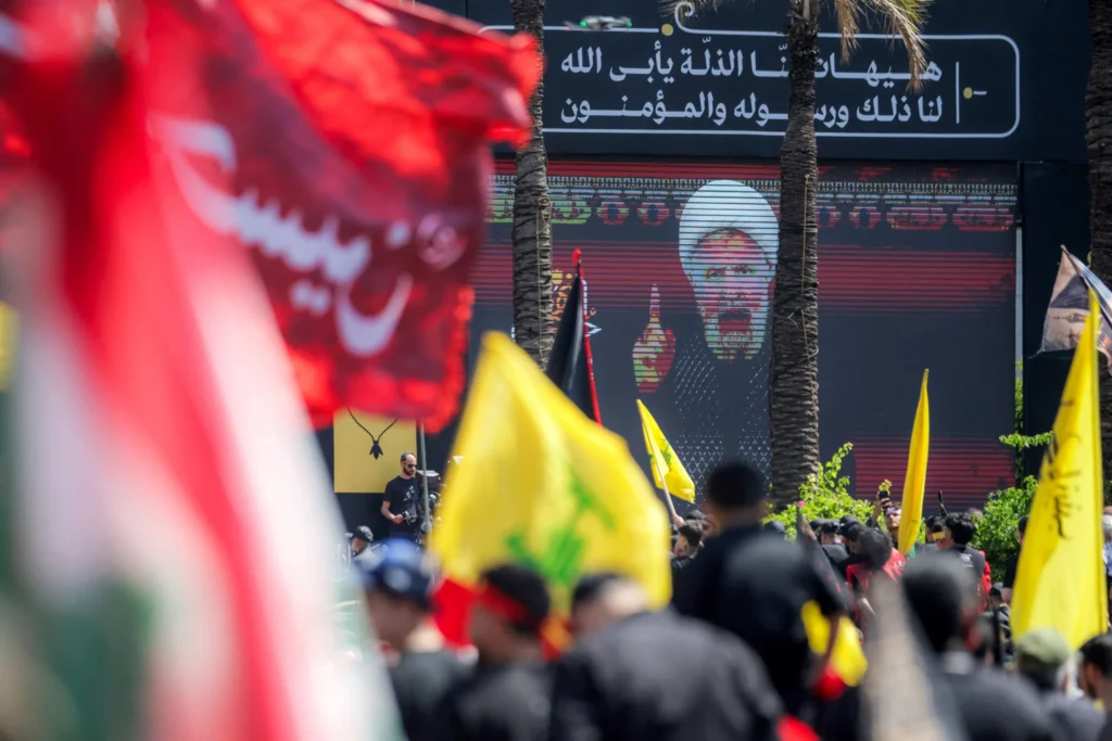 Uma multidão assiste à transmissão de um discurso de Naim Qassem, líder do Hezbollah