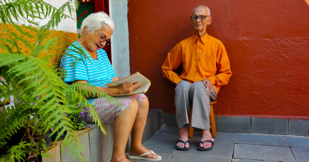 casal de idosos sentados em um quintal